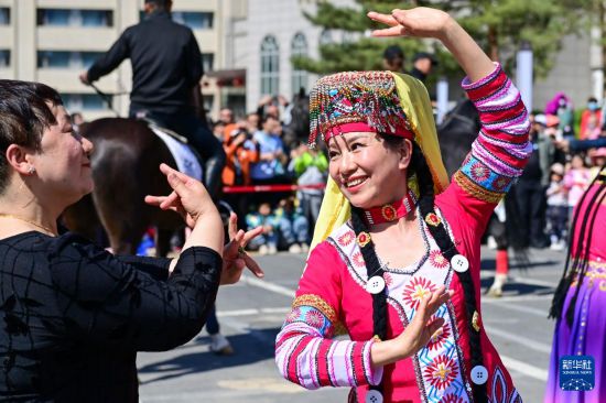 4月30日，在新疆乌鲁木齐市举行的巡游活动上，市民和游客一起跳麦西来甫。
